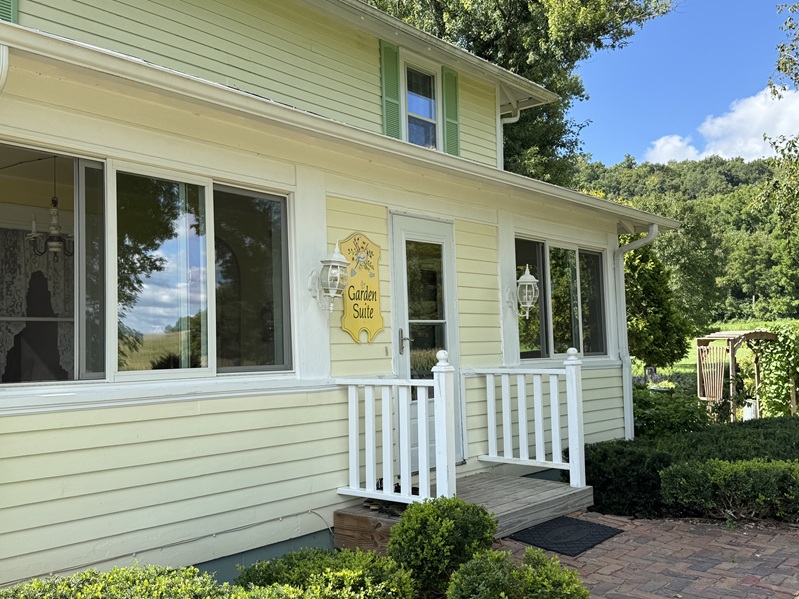Private entrance to Garden Suite porch at foursquare yellow farmhouse.