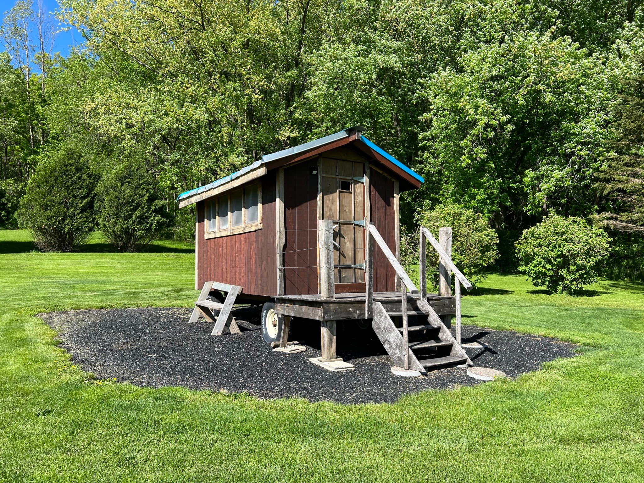 The Snuggalo is a tiny wooden house situated in its own little camp space near the woods.