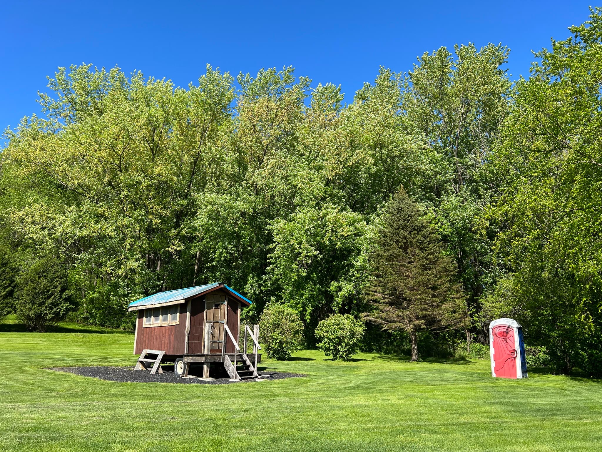 The Snuggalo is serviced by a porta potty just a short distance away near the tree line.