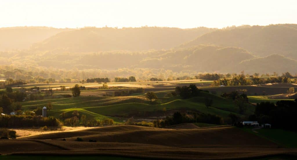 Sunlit rolling hills and valleys at dusk.