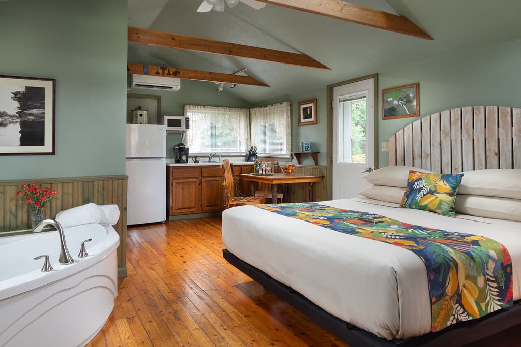 Bedroom with kitchenette, dining table, bed, and jetted tub