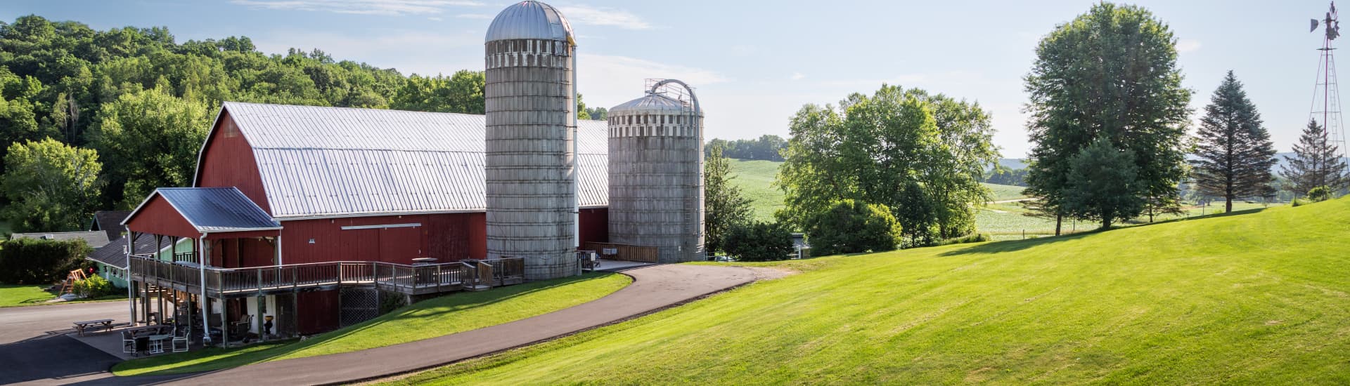 Red barn, two silos in surrounding green grass