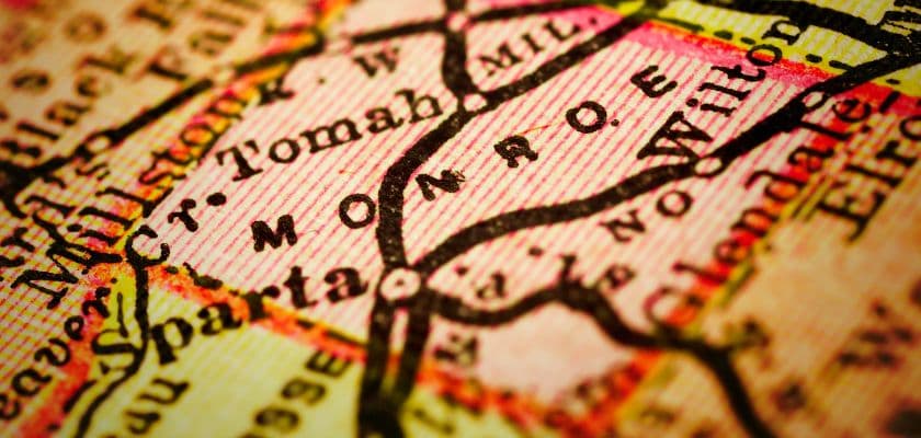 A close-up of a vintage map showing the name "Monroe" along with nearby towns and roads.