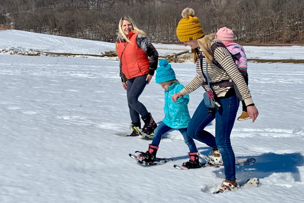 A family snowshoeing through the snow