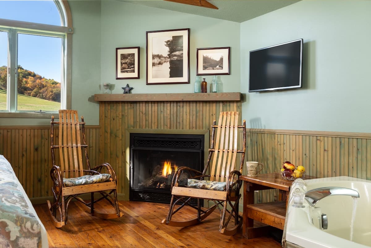 Cozy living area featuring a fireplace, two rocking chairs, a wall-mounted TV, and mountain views.