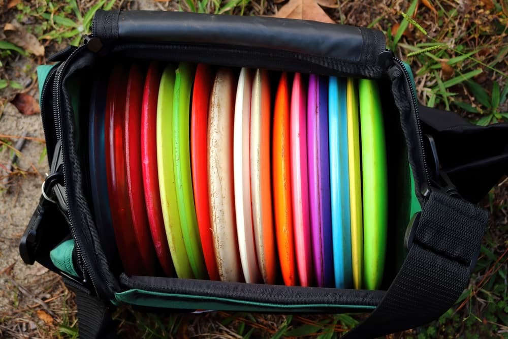 A disc golf bag filled with colorful discs arranged neatly inside.
